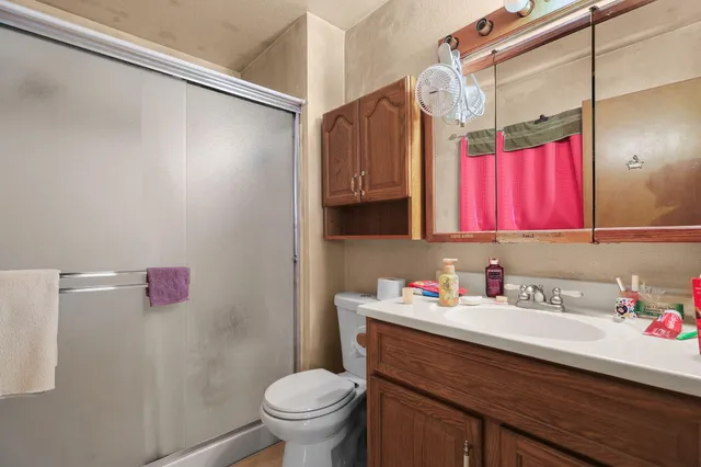 a bathroom with a sink toilet vanity and shower