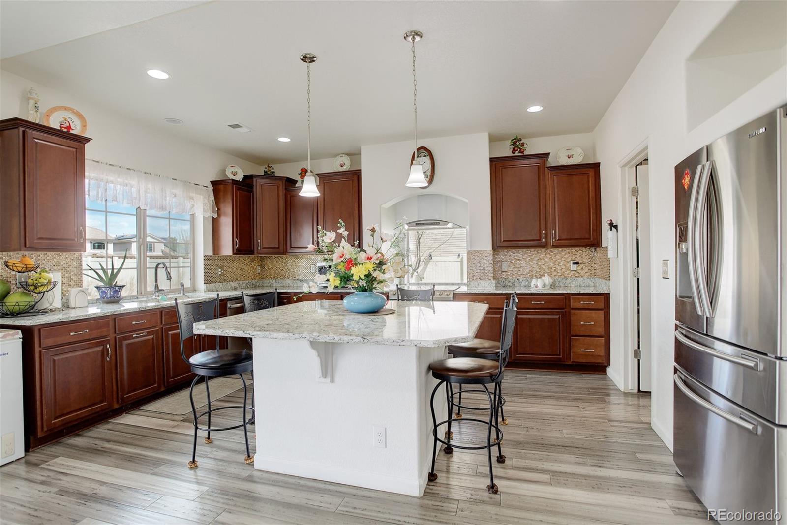 4971 Ceylon Way Denver, CO 80249 - Photo 11 of 40 a kitchen with kitchen island granite countertop a sink cabinets and stainless steel appliances