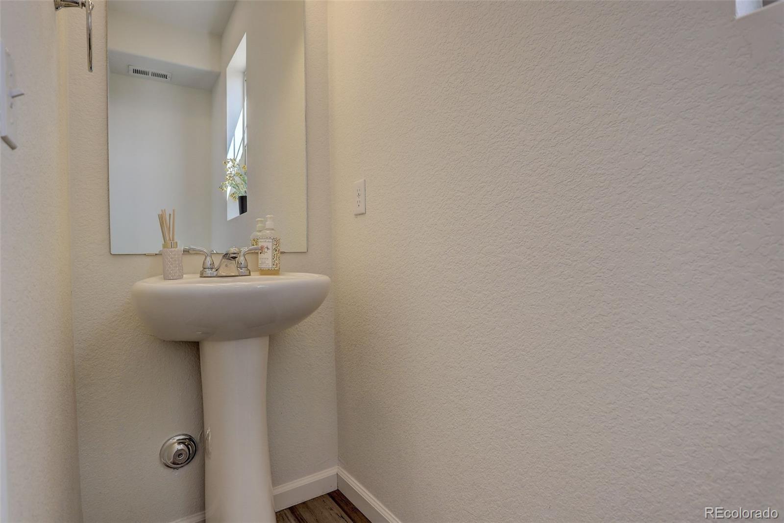 4971 Ceylon Way Denver, CO 80249 - Photo 14 of 40 a bathroom with a sink a mirror and toilet
