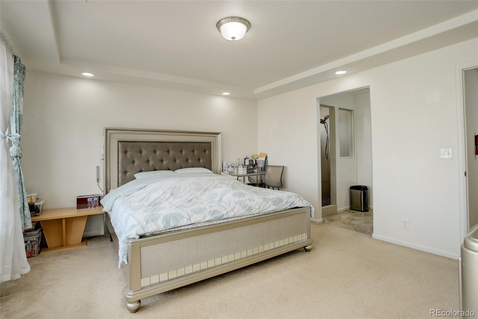 4971 Ceylon Way Denver, CO 80249 - Photo 16 of 40 a bedroom with a bed and a lamp