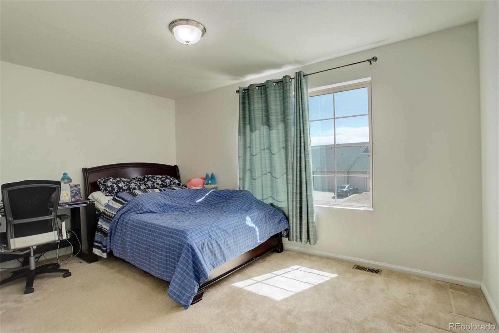 4971 Ceylon Way Denver, CO 80249 - Photo 21 of 40 a bedroom with a bed and window
