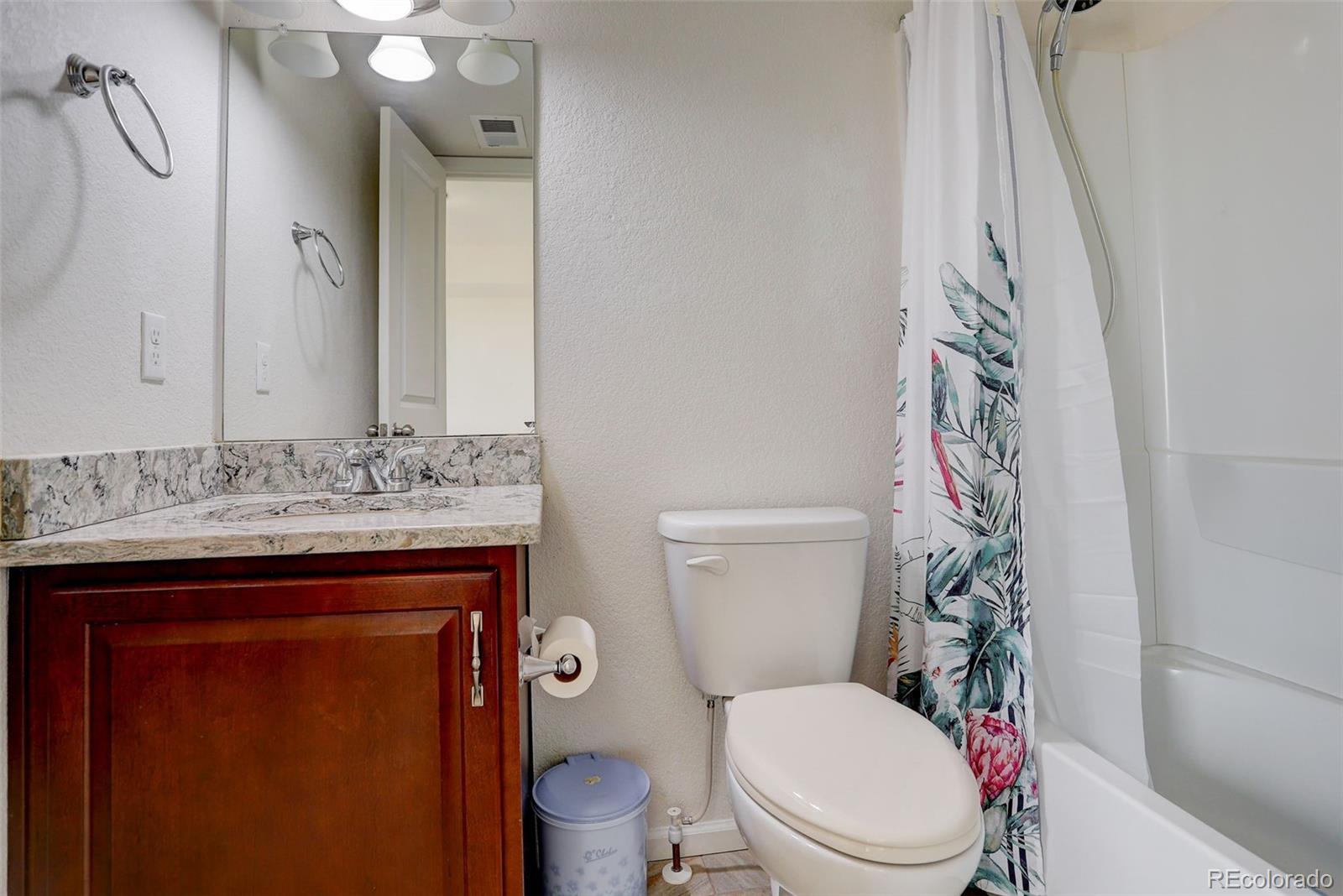 4971 Ceylon Way Denver, CO 80249 - Photo 25 of 40 a bathroom with a toilet sink and mirror