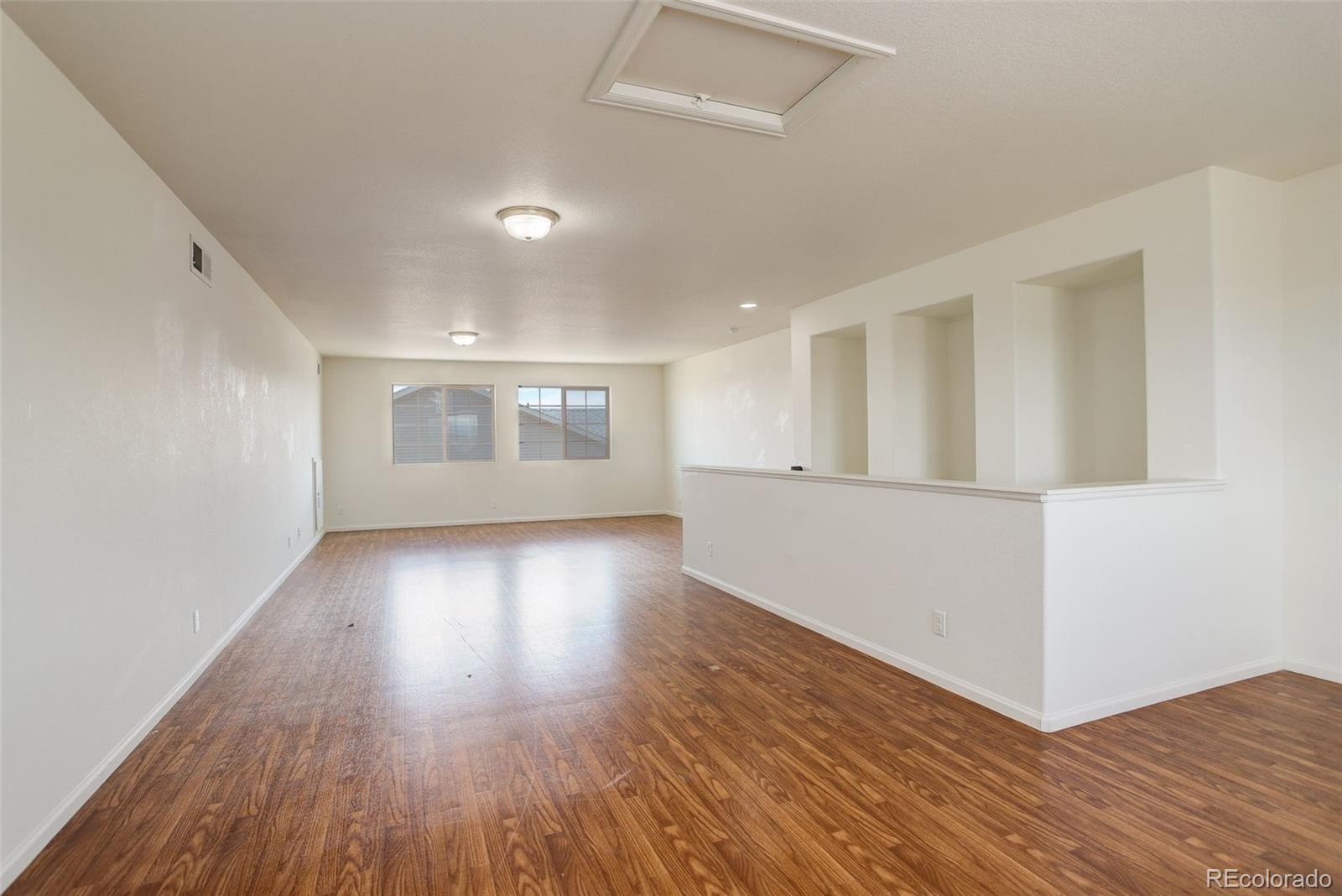 4971 Ceylon Way Denver, CO 80249 - Photo 30 of 40 a view of an empty room with wooden floor and a window