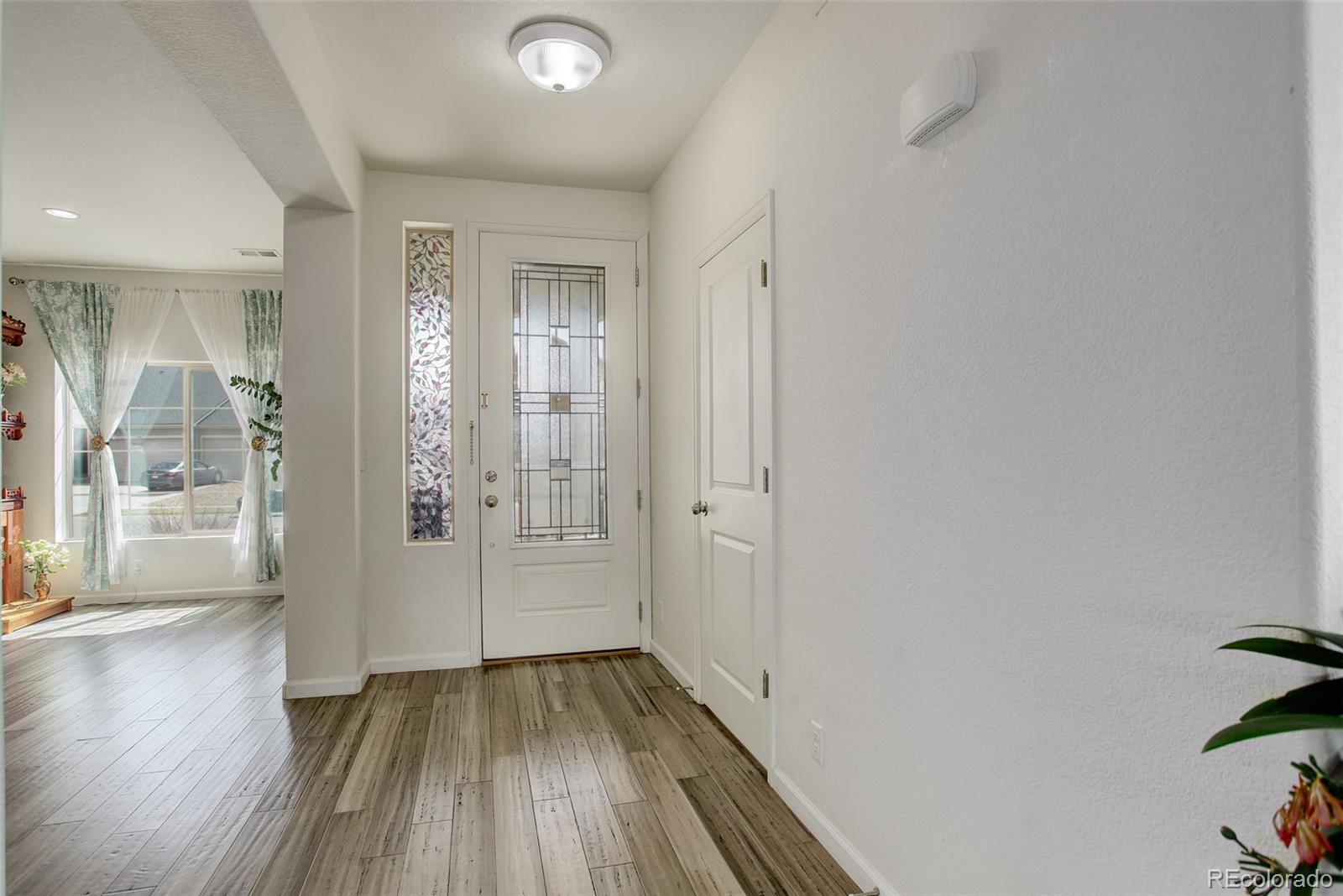 4971 Ceylon Way Denver, CO 80249 - Photo 5 of 40 a view of a hallway with wooden floor and a bathroom