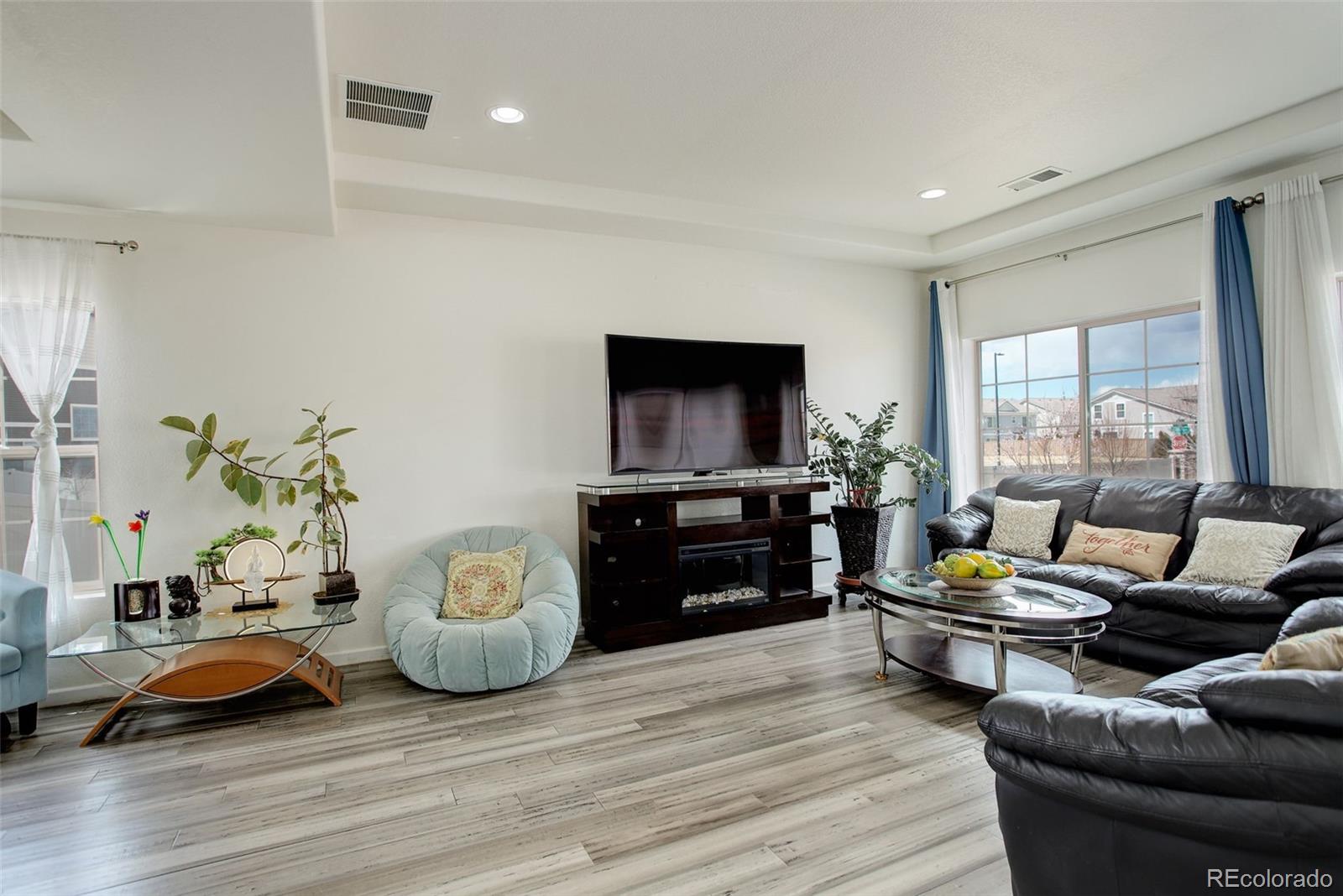 4971 Ceylon Way Denver, CO 80249 - Photo 9 of 40 a living room with furniture and a flat screen tv