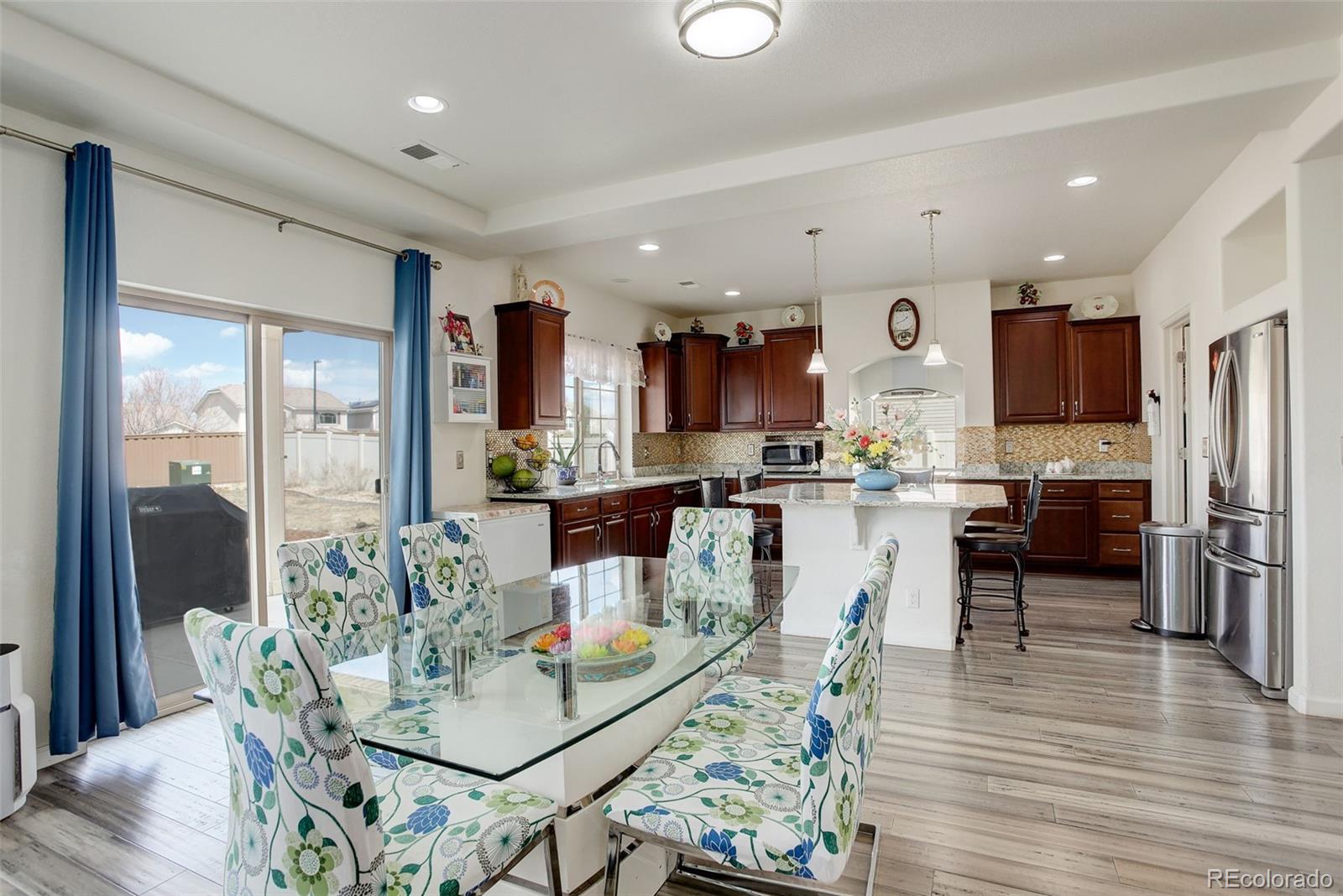4971 Ceylon Way Denver, CO 80249 - Photo 10 of 40 a view of a dining room and livingroom with furniture wooden floor and a view of kitchen