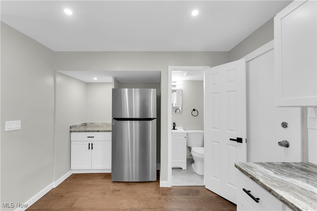 797 Babbitt Road, Unit 15 Euclid, OH 44123 - Photo 9 of 22 Kitchen featuring freestanding refrigerator, white cabinets, light stone countertops, dark wood-style flooring, and recessed lighting