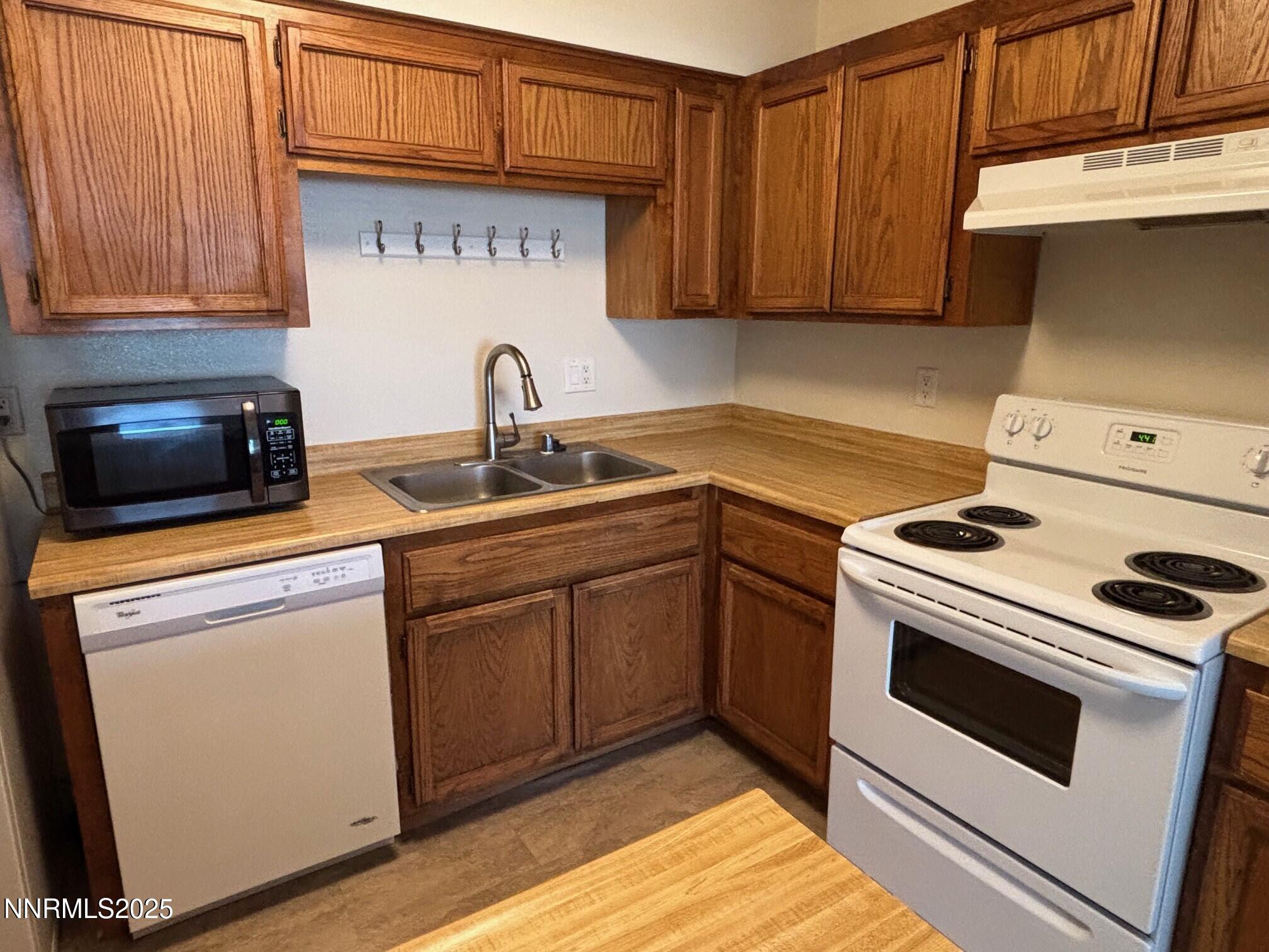 1465 East Peckham Lane, Unit 53 Reno, NV 89502 - Photo 3 of 19 a kitchen with sink a microwave and cabinets