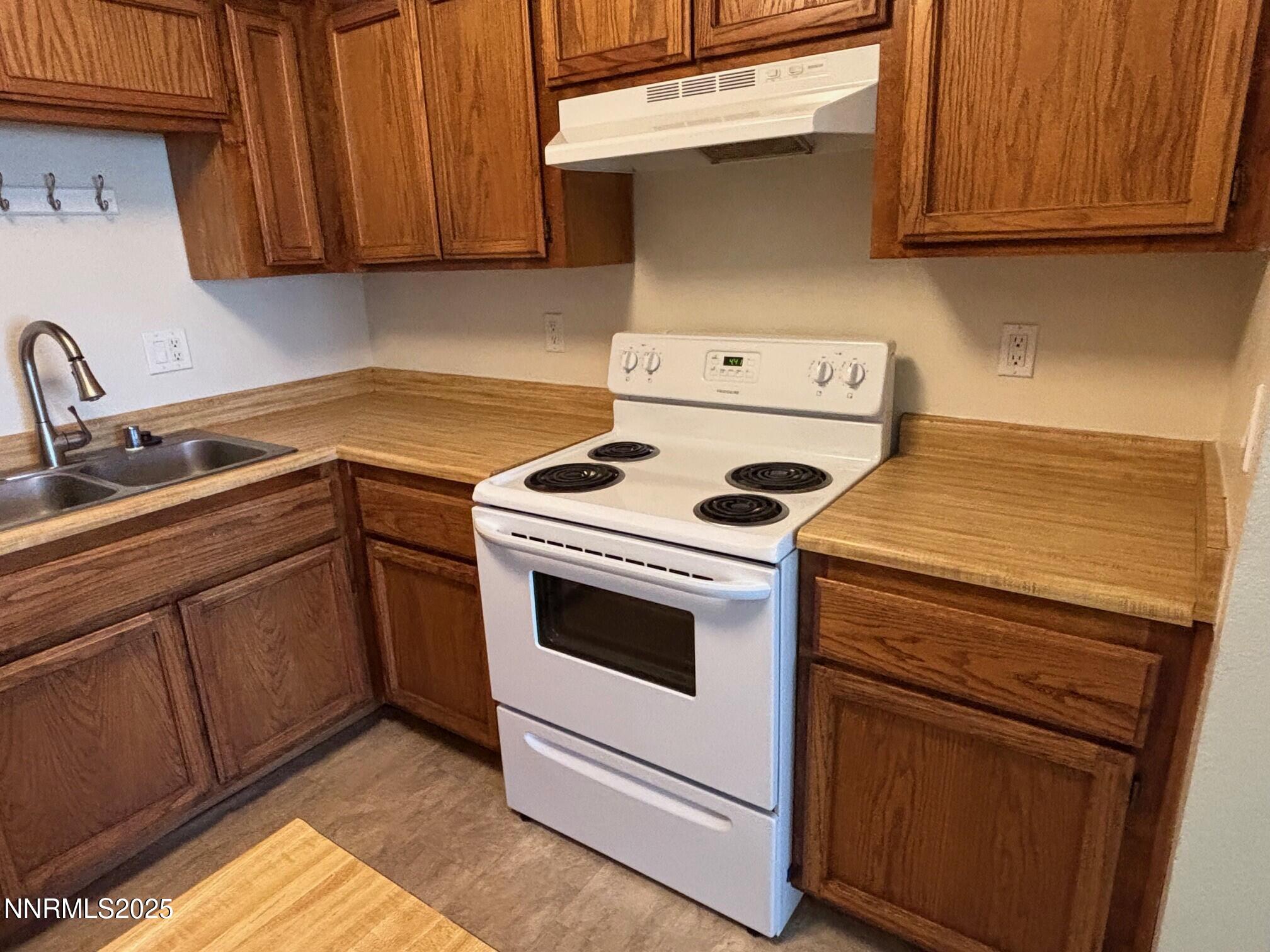 1465 East Peckham Lane, Unit 53 Reno, NV 89502 - Photo 4 of 19 a kitchen with sink a stove and cabinets