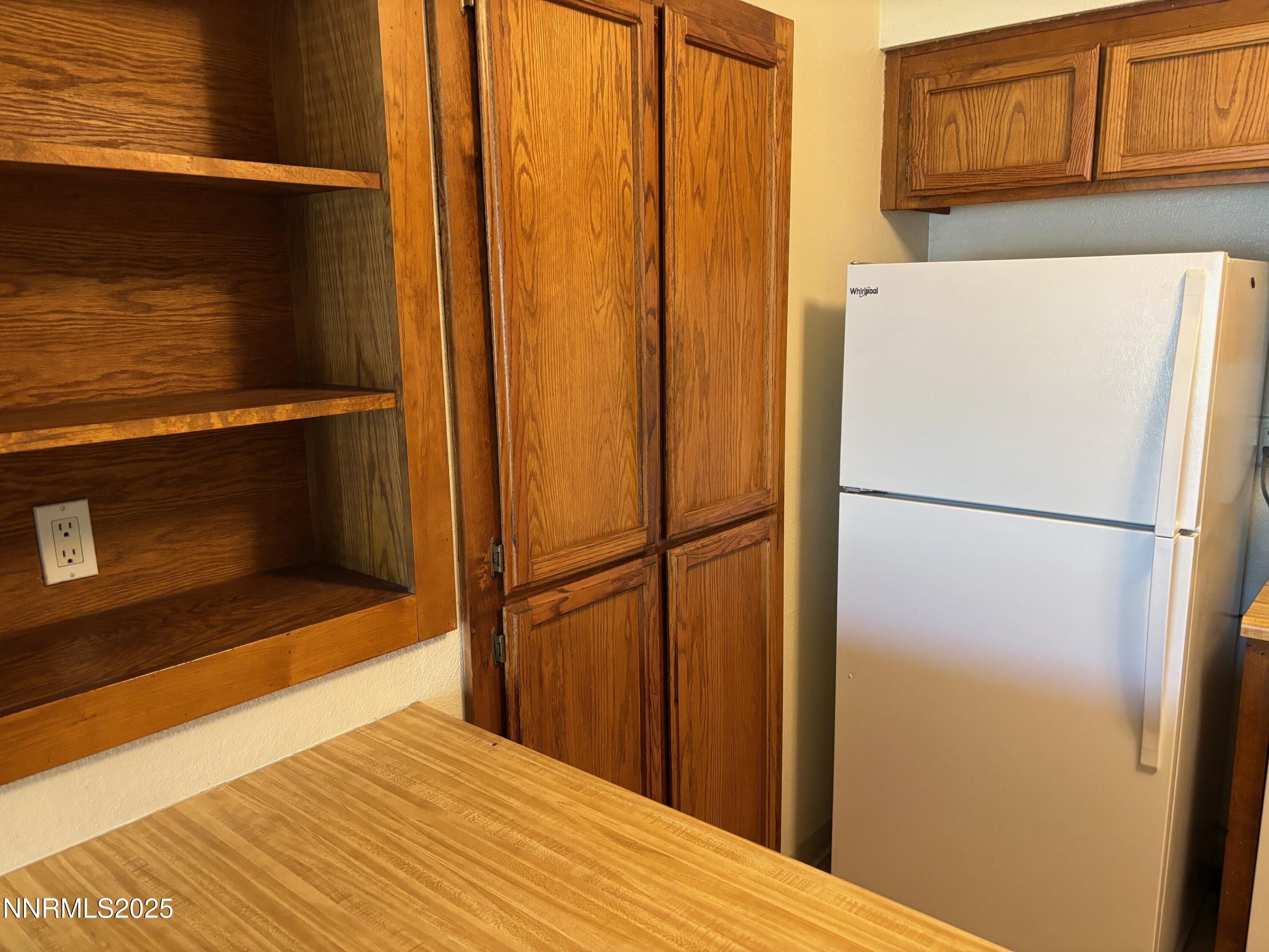 1465 East Peckham Lane, Unit 53 Reno, NV 89502 - Photo 5 of 19 a view of a kitchen with wooden floor and a refrigerator