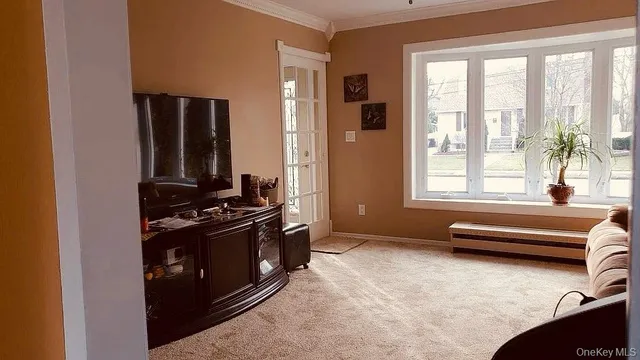 a living room with furniture and a floor to ceiling window