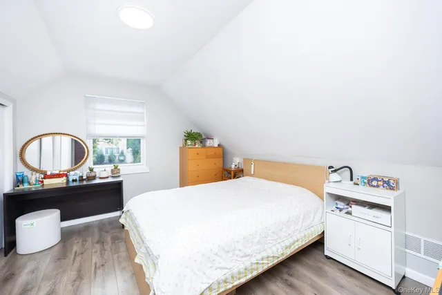 a bedroom with a bed and a wooden floor