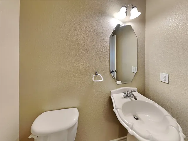 an empty room with wooden floor chandelier fan and windows