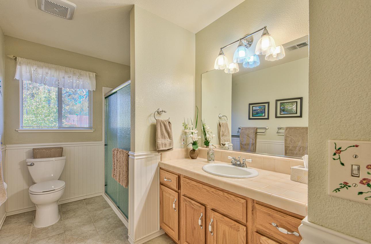18401 Moro Road Salinas, CA 93907 - Photo 30 of 39 a bathroom with a toilet a sink a light fixture and mirror