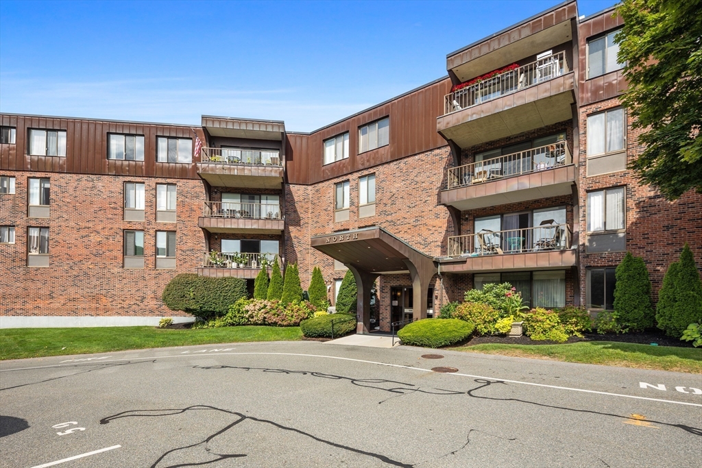 1006 Paradise Road, Unit 1A Swampscott, MA 01907 - Photo 17 of 18 a front view of a multi story residential apartment building with yard and green space