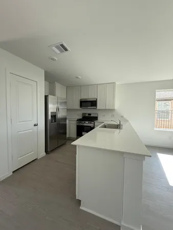 a kitchen with cabinets and stainless steel appliances