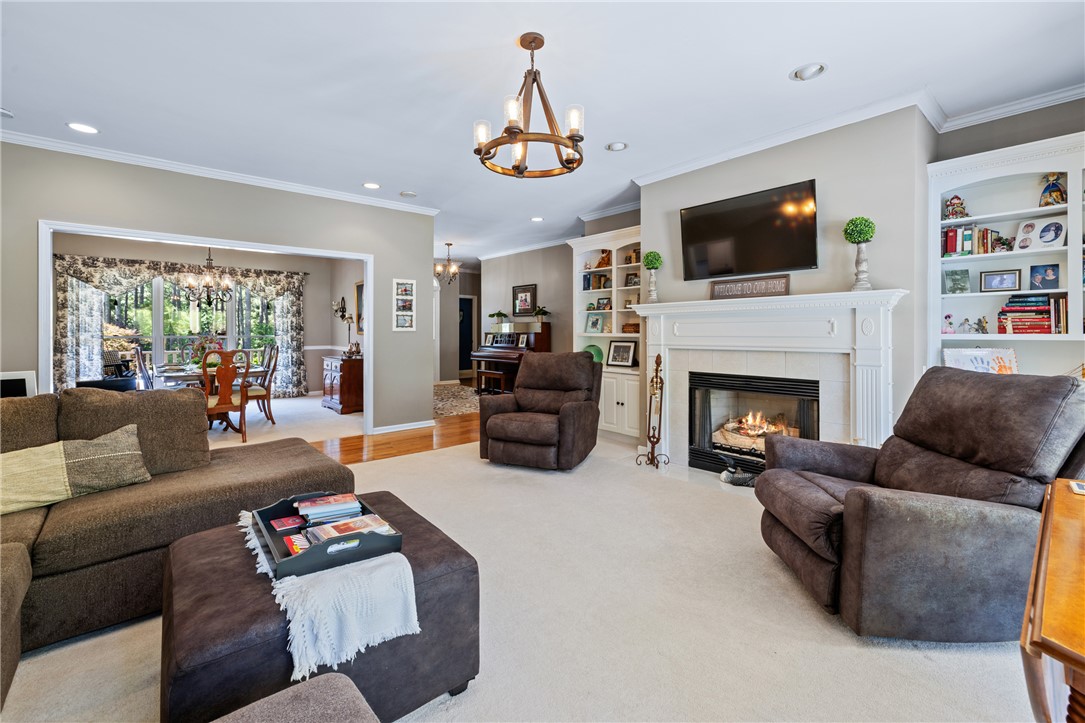 308 Amethyst Way Seneca, SC 29672 - Photo 9 of 49 The heart of the home features a bright, open living room with built-in bookcases flanking a tiled propane fireplace, flowing seamlessly into a formal dining room and an expansive kitchen/breakfast area.