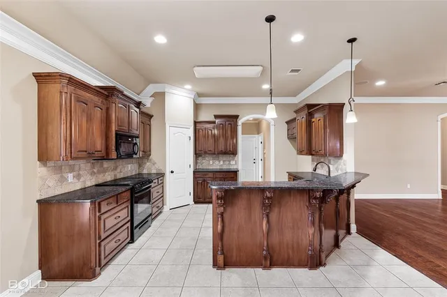 a large kitchen with a large counter top stainless steel appliances and cabinets