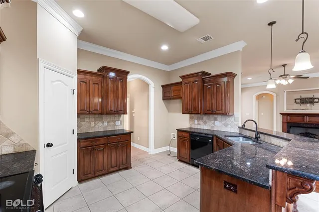 a large kitchen with granite countertop a stove and a sink