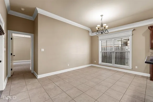 a view of an empty room with a chandelier fan