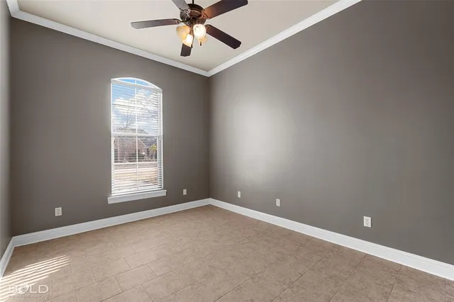 a view of an empty room with a chandelier fan
