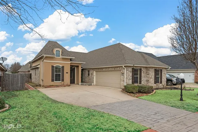 a front view of a house with a garden and yard