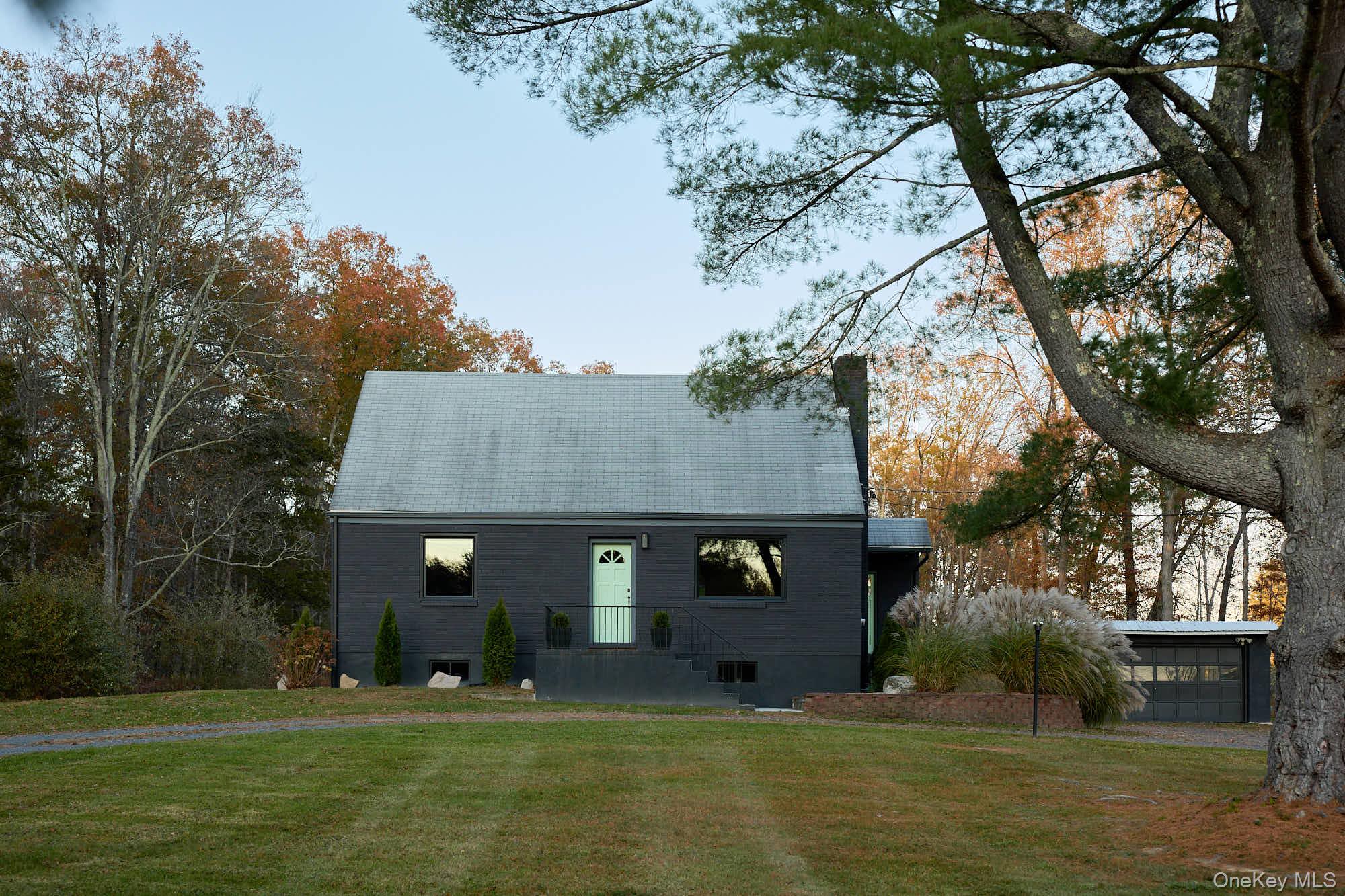 a front view of a house with a garden and tree
