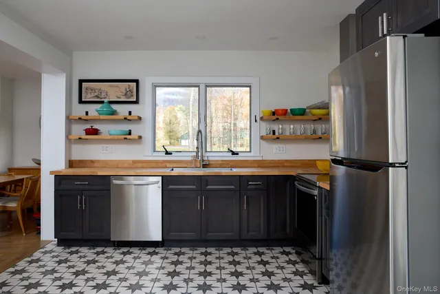 a kitchen with stainless steel appliances granite countertop a refrigerator and a sink