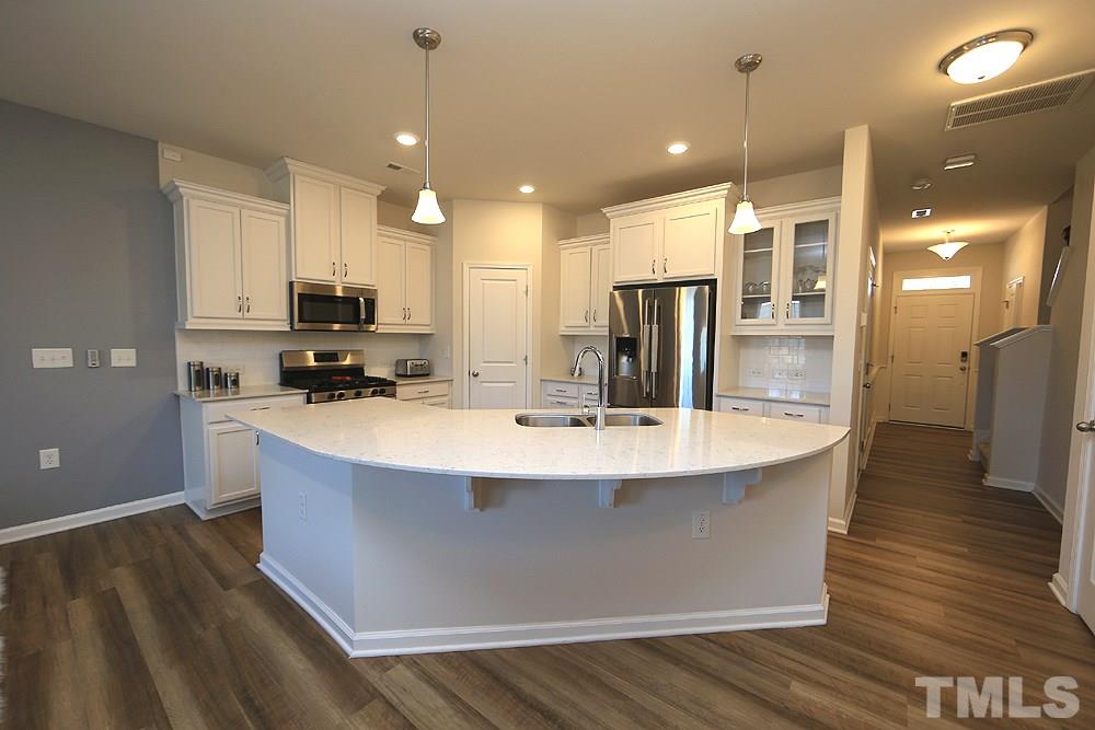 6108 Beale Loop Raleigh, NC 27616 - Photo 2 of 19 a kitchen with kitchen island a sink appliances and cabinets