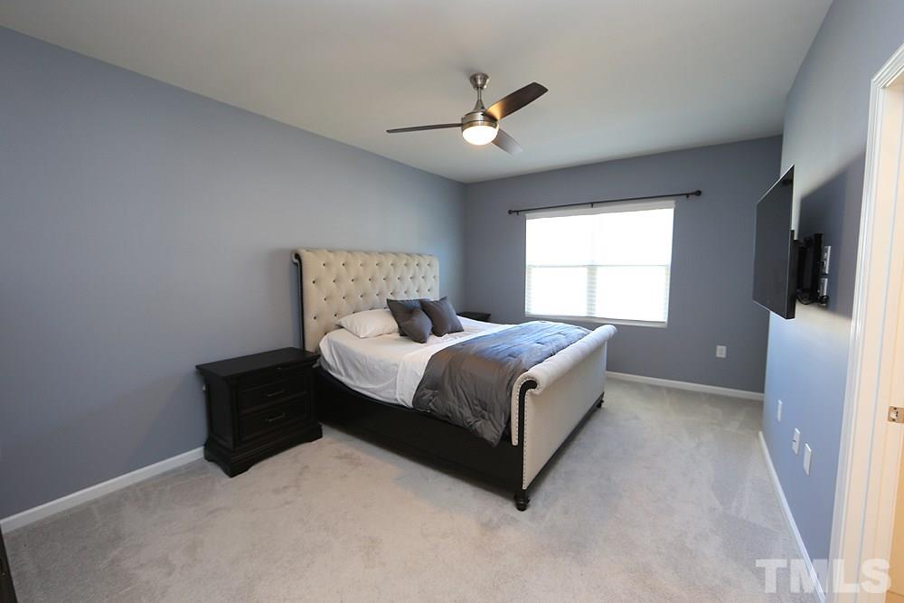 6108 Beale Loop Raleigh, NC 27616 - Photo 8 of 19 a bed room with a bed and a chandelier