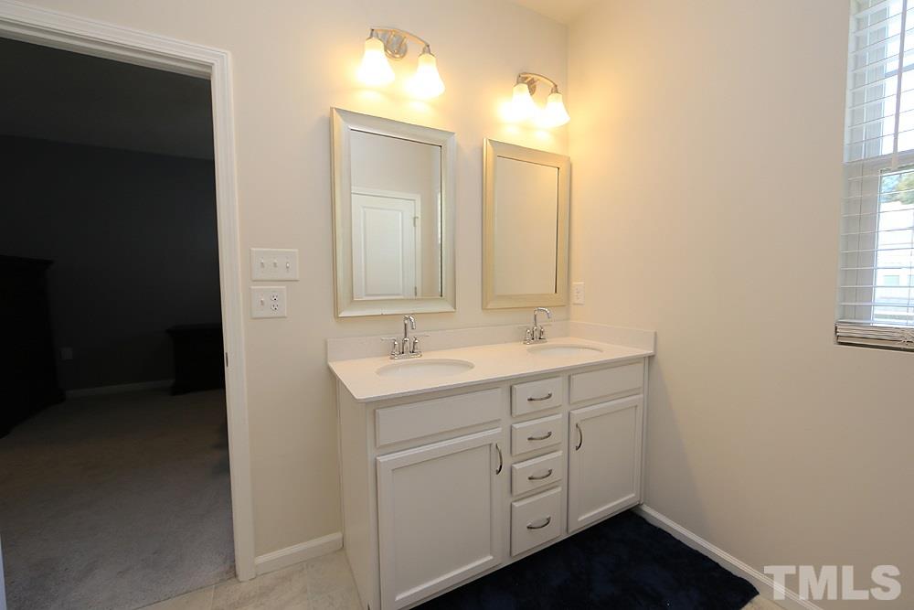 6108 Beale Loop Raleigh, NC 27616 - Photo 9 of 19 a bathroom with a double vanity sink and mirror with window