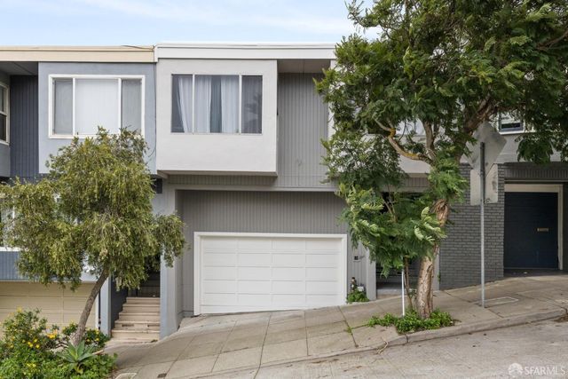 a front view of a house with a garden