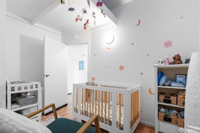 a view of a hallway with furniture and wooden floor