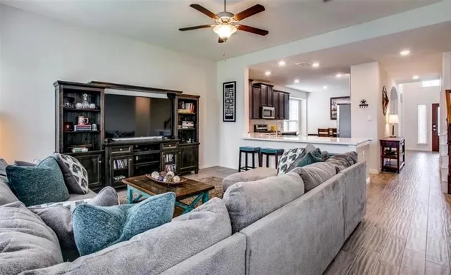a living room with furniture and a flat screen tv with wooden floor
