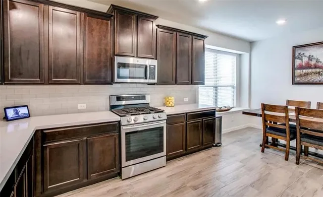 a kitchen with granite countertop wooden cabinets and stainless steel appliances