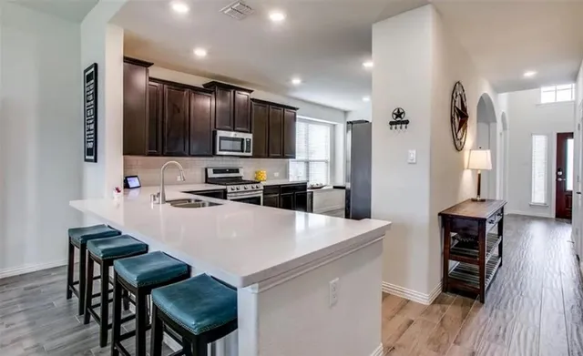 a kitchen with kitchen island wooden cabinets a stove a sink and a refrigerator