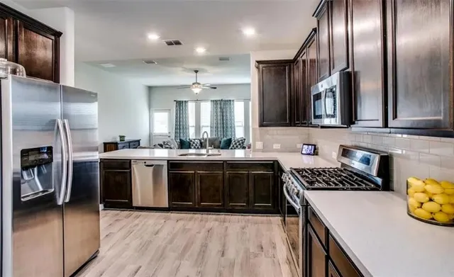 a kitchen with stainless steel appliances granite countertop a stove a sink and a refrigerator