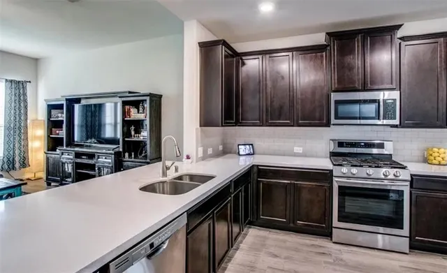 a kitchen with a sink stove and microwave