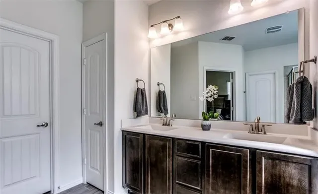 a bathroom with double sink and a mirror