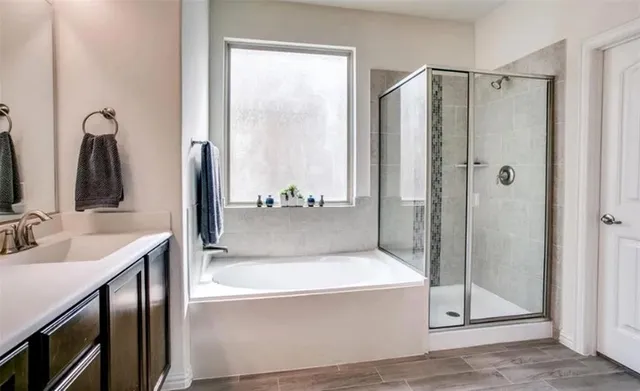 a bathroom with a tub shower and sink