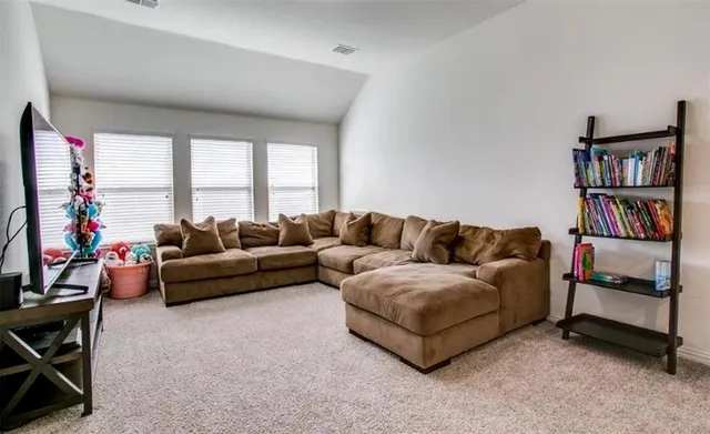 a living room with furniture and a book shelf