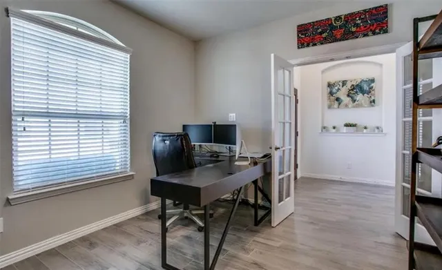 a view of a workspace with furniture and a window