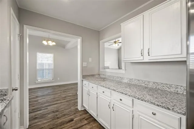 a kitchen with granite countertop white cabinets and a sink