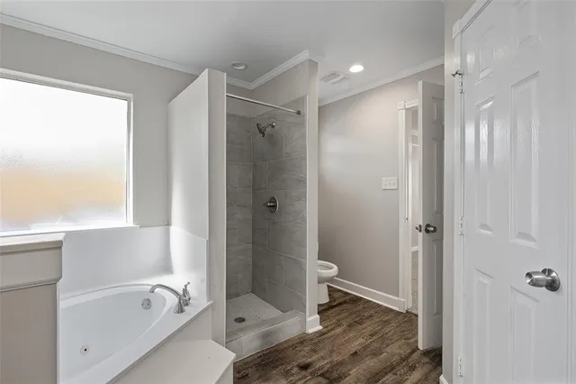 a bathroom with a tub shower vanity and a toilet