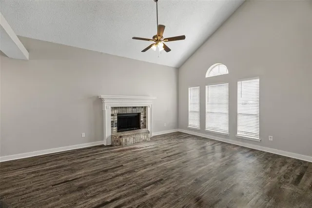 an empty room with windows fireplace and a sink