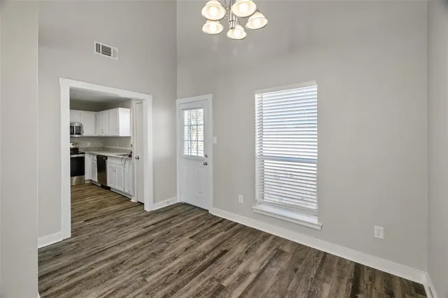 a view of a kitchen from the hallway with a window
