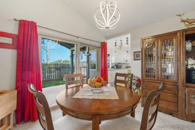 a dining room with furniture a chandelier and wooden floor