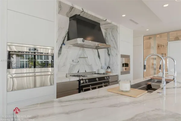 a kitchen with kitchen island stainless steel appliances a sink and a refrigerator