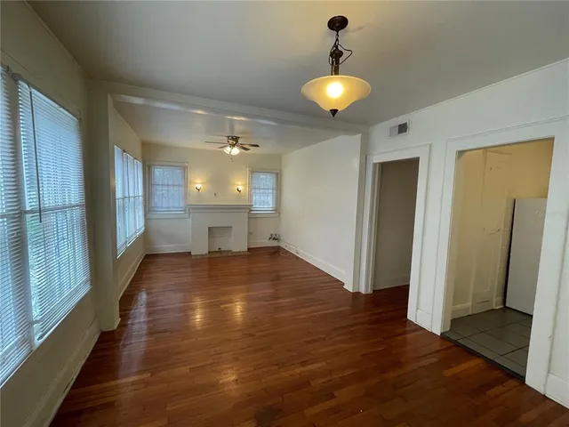 a view of a hallway with wooden floor and a chandelier