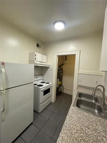a kitchen with a stove a refrigerator and a sink